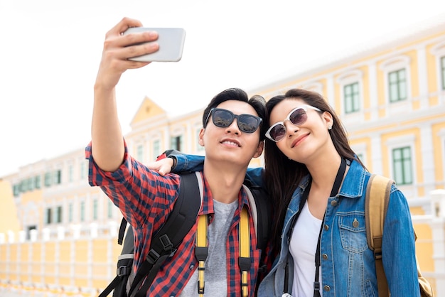 Porträt eines jungen glücklichen asiatischen Touristenpaares in Freizeitkleidung, das auf Reisen in Bangkok Thailand ein Selfie macht