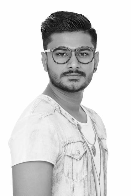 Porträt eines jungen gutaussehenden bärtigen indischen Mannes auf weiß in schwarz und weiß