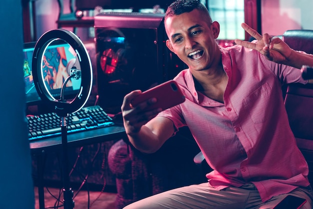 Porträt eines jungen hispanischen professionellen Spielers, der ein Selfie macht
