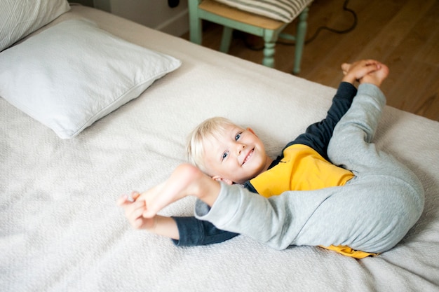 Porträt eines Jungen im Kinderzimmer auf dem Bett