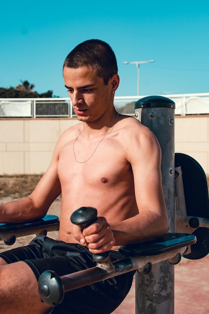 Porträt eines jungen kaukasischen Jungen, der einige Dips in einem Calisthenics-Park macht