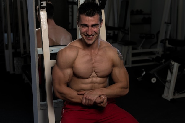 Porträt eines jungen körperlich fitten Mannes, der seinen gut trainierten Körper zeigt muskulöser athletischer Bodybuilder Fitness Model posiert nach Übungen