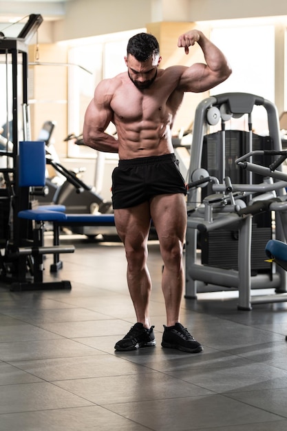 Porträt eines jungen körperlich fitten Mannes, der seinen gut trainierten Körper zeigt muskulöser athletischer Bodybuilder Fitness Model posiert nach Übungen