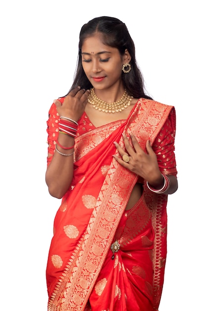 Porträt eines jungen Mädchens auf indischem traditionellem Saree, das auf weißem Hintergrund posiert