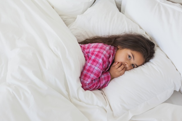 Porträt eines jungen Mädchens, das im Bett stillsteht