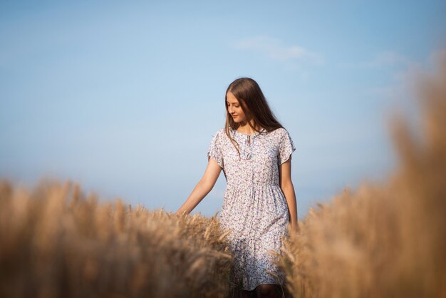 Porträt eines jungen Mädchens im weißen Kleid im Weizenfeld