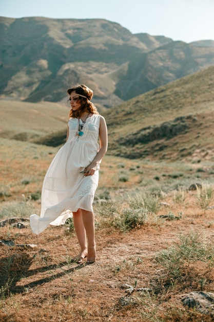 Porträt eines jungen Mädchens in einem weißen lichtdurchlässigen Kleid in der Boho- oder Hippieart