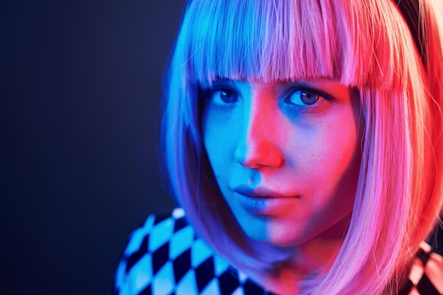 Porträt eines jungen Mädchens mit blonden Haaren in rotem und blauem Neon im Studio