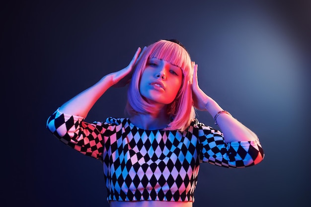 Porträt eines jungen Mädchens mit blonden Haaren in rotem und blauem Neon im Studio