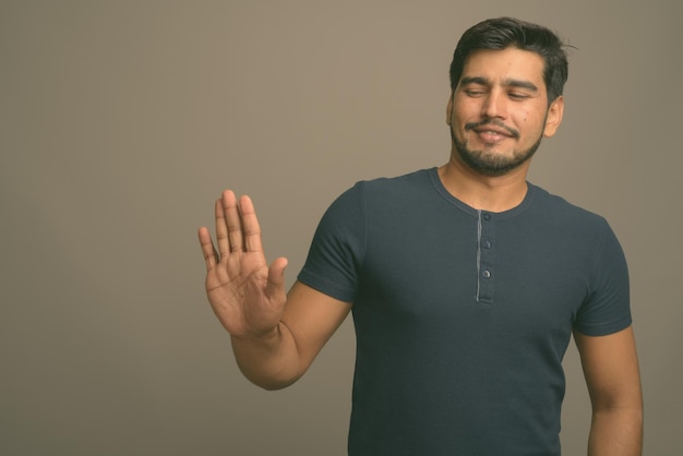 Foto porträt eines jungen mannes, der an der wand steht