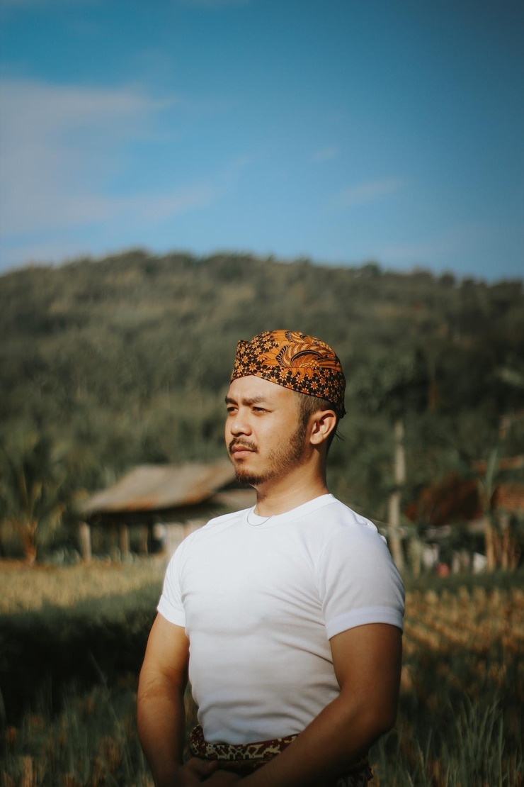 Foto porträt eines jungen mannes, der auf dem feld gegen den himmel steht