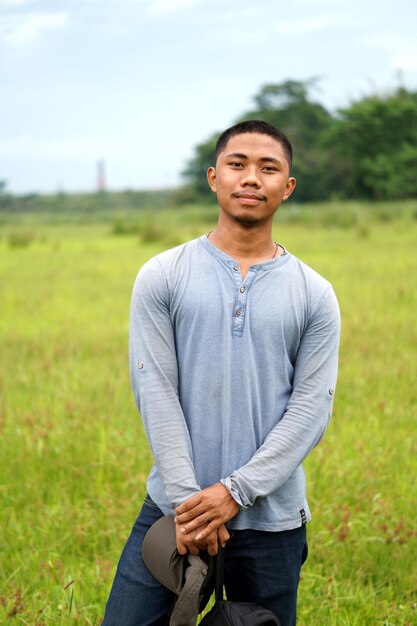 Foto porträt eines jungen mannes, der auf dem feld steht