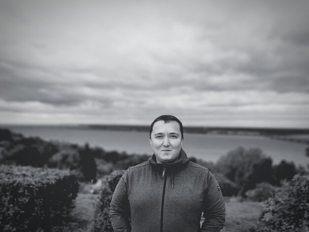 Foto porträt eines jungen mannes, der auf dem land gegen den himmel steht