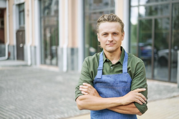 Foto porträt eines jungen mannes, der auf einem fußweg in der stadt sitzt