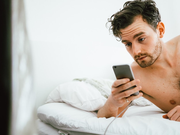 Porträt eines jungen Mannes, der ein Handy benutzt