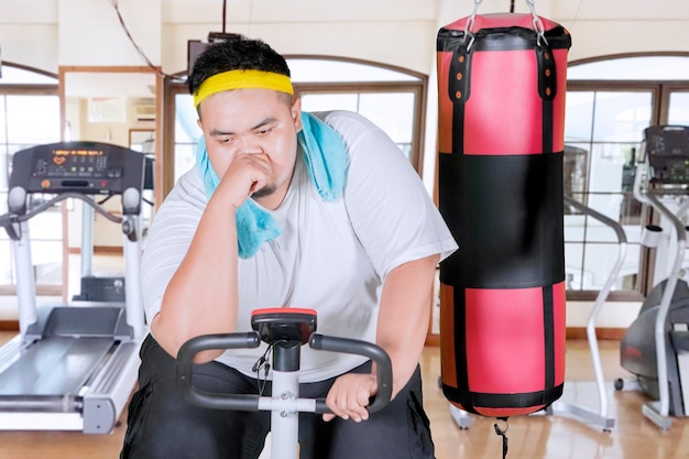 Foto porträt eines jungen mannes, der im fitnessstudio trainiert