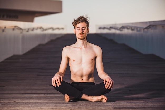 Foto porträt eines jungen mannes, der im freien sitzt