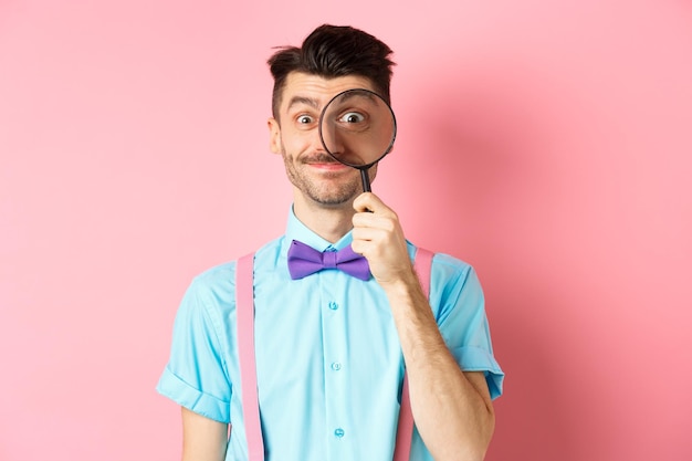 Foto porträt eines jungen mannes, der vor einem rosa hintergrund steht