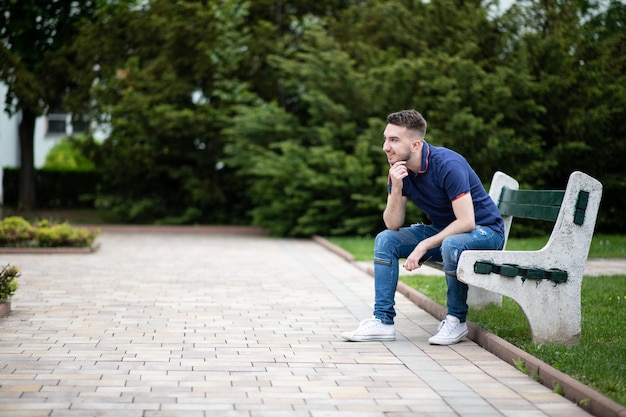 Porträt eines jungen Mannes draußen im Park