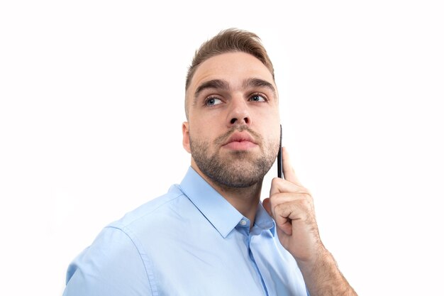 Porträt eines jungen Mannes im Business-Stil, der auf weißem Hintergrund telefoniert