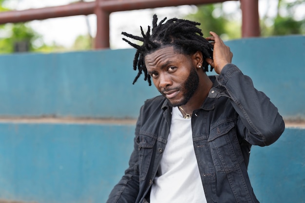 Foto porträt eines jungen mannes mit afro-dreadlocks und jacke