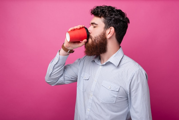 Porträt eines jungen Mannes mit Bart, der Kaffee trinkt