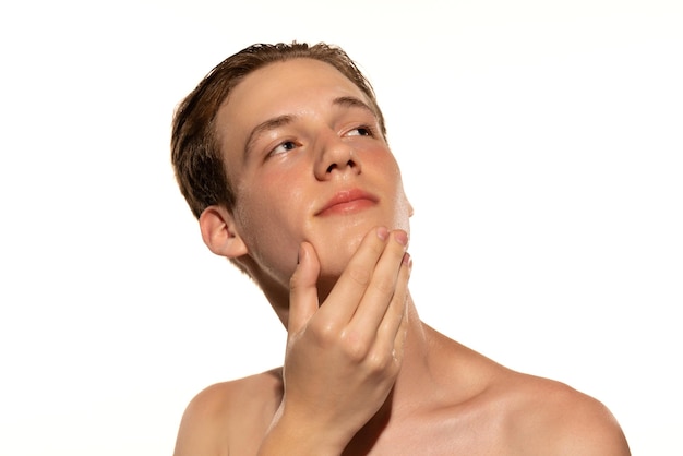 Porträt eines jungen Mannes mit sauberem Gesicht nach der Rasur posiert isoliert über dem ganzen Studiohintergrund