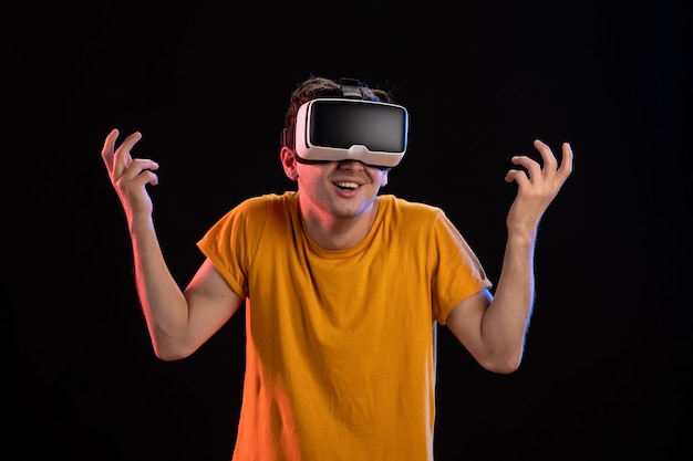 Porträt eines jungen Mannes mit VR-Headset an der dunklen Wand