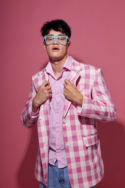 Porträt eines jungen Mannes modische Brille rosa Blazer posiert Studio rosa Hintergrund unverändert