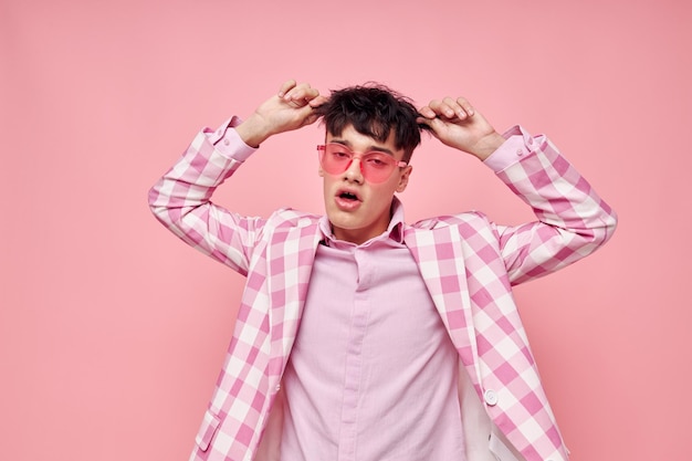 Porträt eines jungen Mannes, rosa Brille, karierte Jacke, Mode, posiert vorbildliches Studio