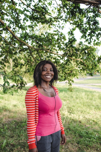 Porträt eines jungen schönen afroamerikanischen Mädchens in einer rosa Bluse, das schwarzes Mädchen lächelt