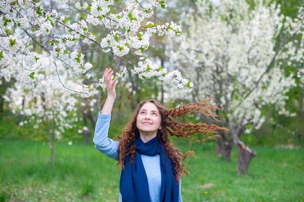 Porträt eines jungen schönen blühenden Parks der modernen Frau im Frühjahr