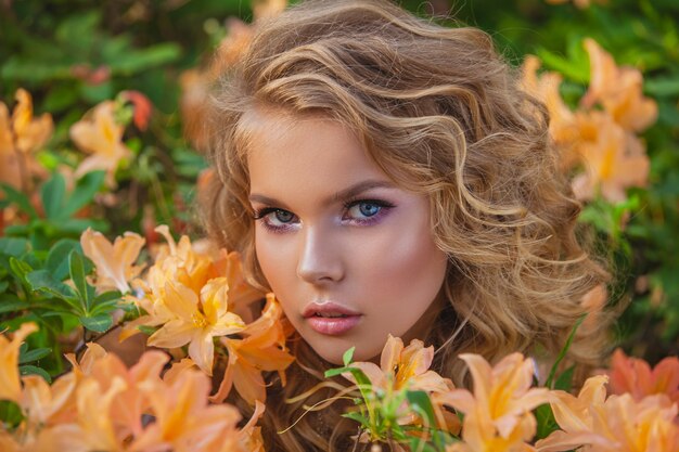 Porträt eines jungen schönen Mädchens in den Blumen.