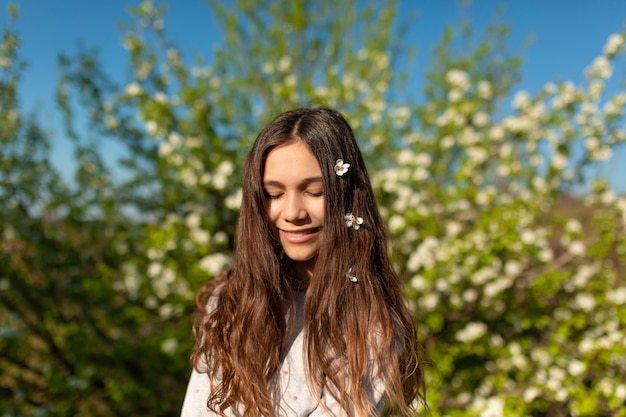 Porträt eines jungen schönen Teenager-Mädchens in einem blühenden Frühlingsgrüngarten.