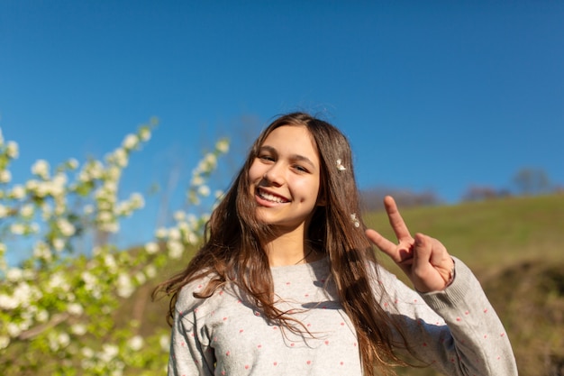 Porträt eines jungen schönen Teenager-Mädchens in einem blühenden Frühlingsgrüngarten.