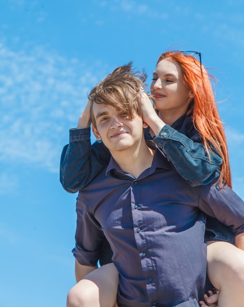 Foto porträt eines jungen, schönen, verliebten paares gegen den himmel