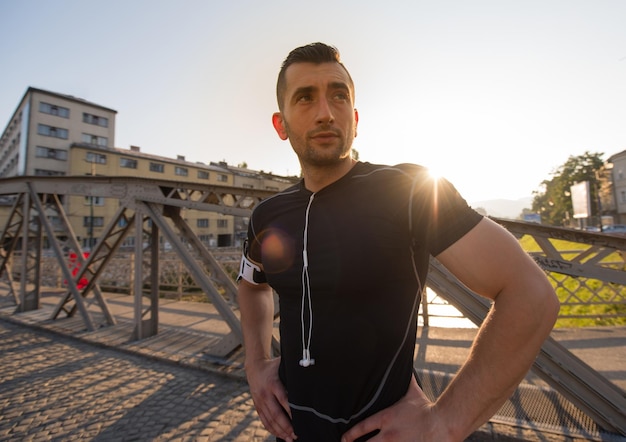 Porträt eines jungen sportlichen Joggers am sonnigen Morgen in der Stadt
