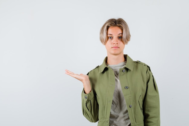 Porträt eines jungen Teenagers, der die Handfläche im T-Shirt beiseite ausbreitet