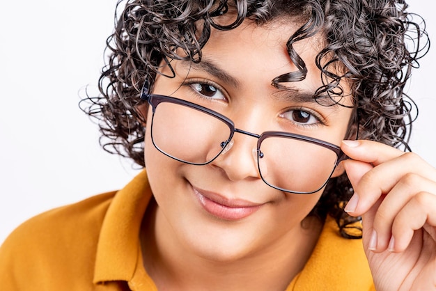 Foto porträt eines jungen teenagers, der sich eine brille aufsetzt und in die kamera schaut