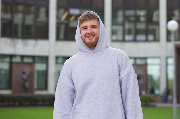 Foto porträt eines jungen universitäts- oder hochschulstudenten auf dem campus im freien mit rucksack