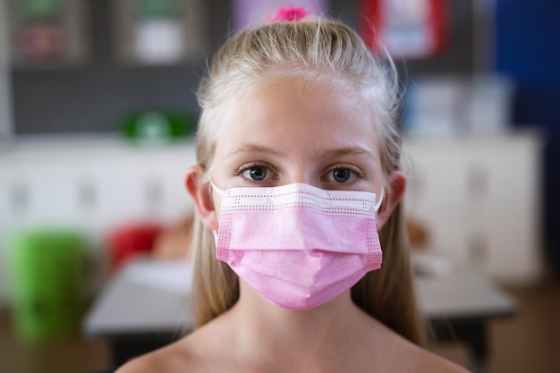 Porträt eines kaukasischen Mädchens mit Gesichtsmaske in der Schule