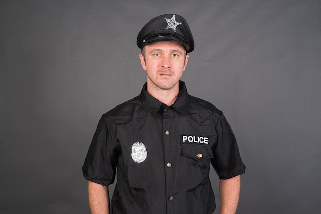 Porträt eines kaukasischen Mannes, der ein Polizeiuniformkostüm trägt