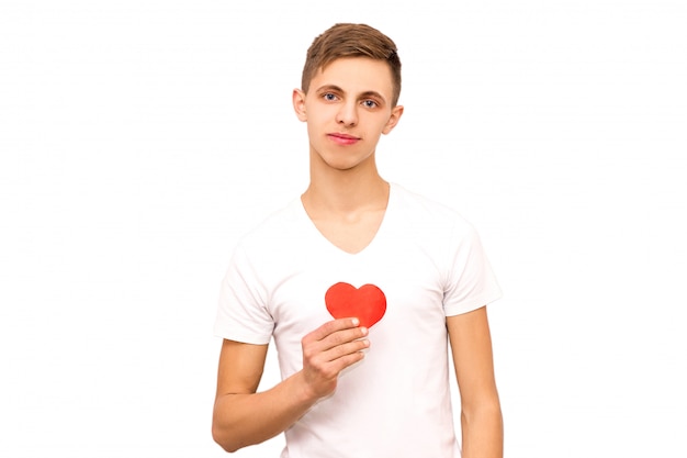Porträt eines Kerls in einem weißen T-Shirt, das ein Herz, Isolat hält