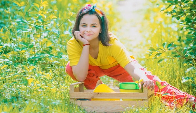 Porträt eines Kindergärtners, der auf dem Bauernhof geerntetes Kind trägt, verbringt Zeit im Obstgarten-Kinderbauern in