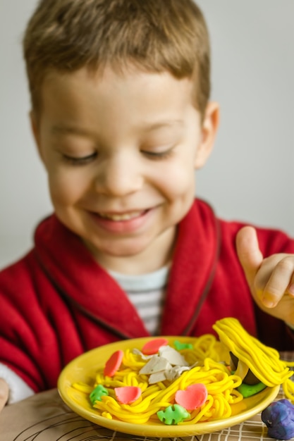 Porträt eines Kindes mit Plastilin-Spaghetti-Gericht