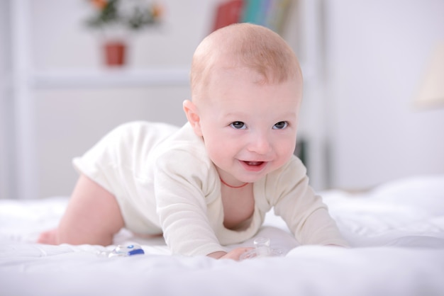 Porträt eines kleinen Babys, das auf Bett spielt.