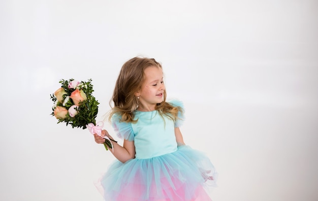 Porträt eines kleinen blonden Mädchens, das einen Strauß frischer Blumen mit Rosen auf weißem Hintergrund hält