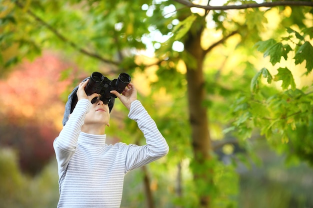 Porträt eines kleinen Jungen, der durch das Fernglas schaut