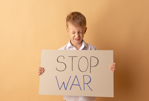 Porträt eines kleinen Jungen hält ein Banner mit der Aufschrift Stoppt den Krieg Kein Krieg stoppt den Krieg