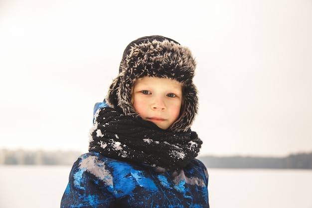 Porträt eines kleinen Jungen in einem Hut im Winter im Park